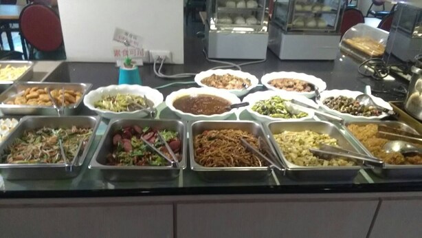 En buffet med et bredt udvalg af mad, herunder salater, kød og grøntsager.