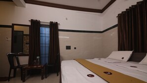 A hotel room with a bed, a desk, and a chair. - GM Residency (Chennai)