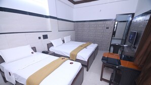 A hotel room with two beds, a desk, a chair, a mirror, and a television. - GM Residency (Chennai)