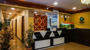 A reception area with a reception desk, a clock, and a sign indicating the reception. - Treebo Hillway Inn Main Market (Mahabaleshwar)