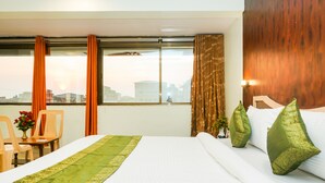 A hotel room with a bed, a desk, and a chair. - Treebo Hillway Inn Main Market (Mahabaleshwar)