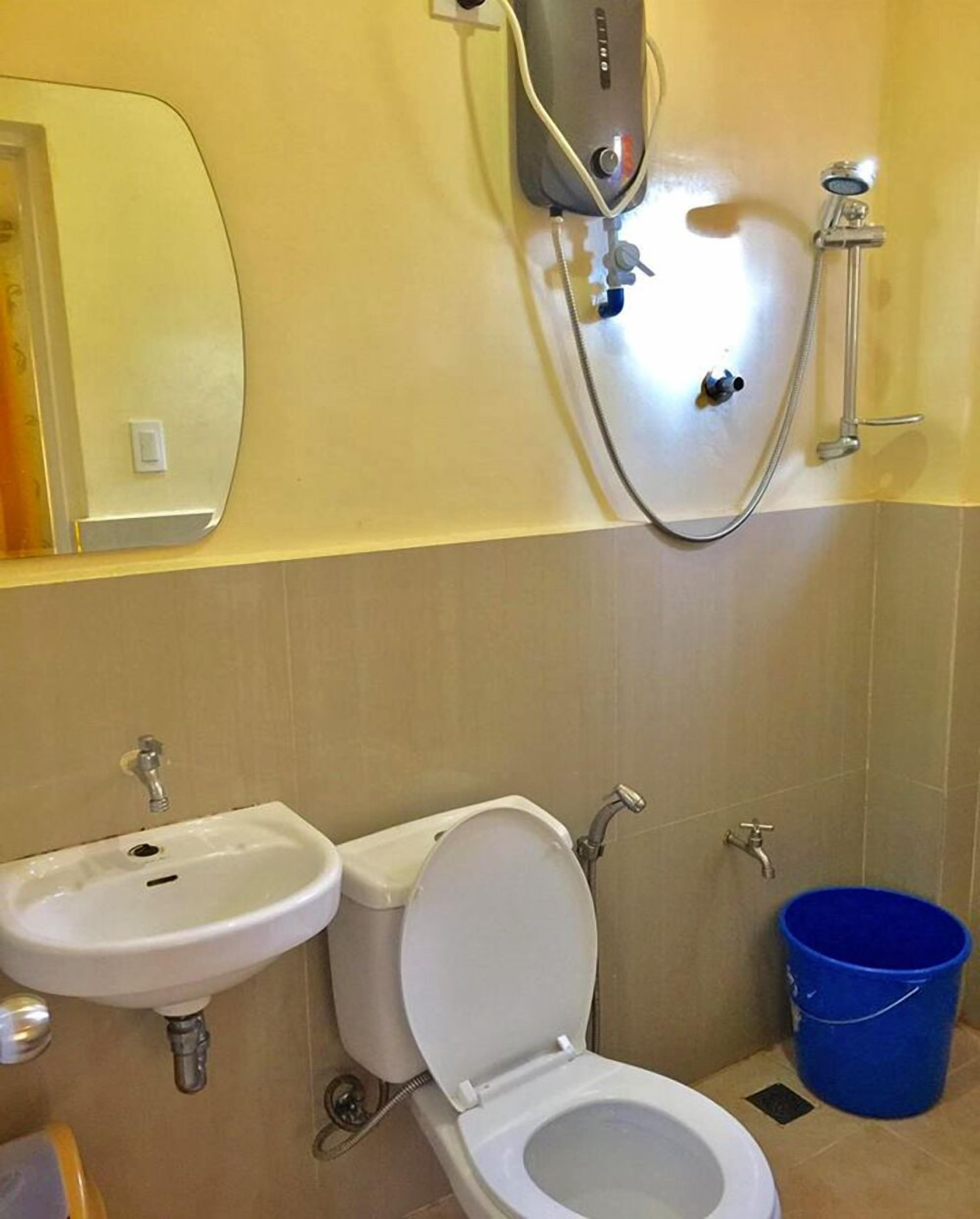A bathroom with a toilet, sink, and shower.