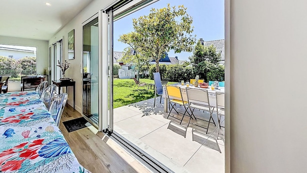 A modern room with a large sliding glass door leading to an outdoor dining area. - Wonderful private villa for 8 people with WIFI, TV, terrace and pets allowed (Saint-philibert)