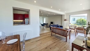 A spacious living area with a dining table, a sofa, and a TV. - Wonderful private villa for 8 people with WIFI, TV, terrace and pets allowed (Saint-philibert)