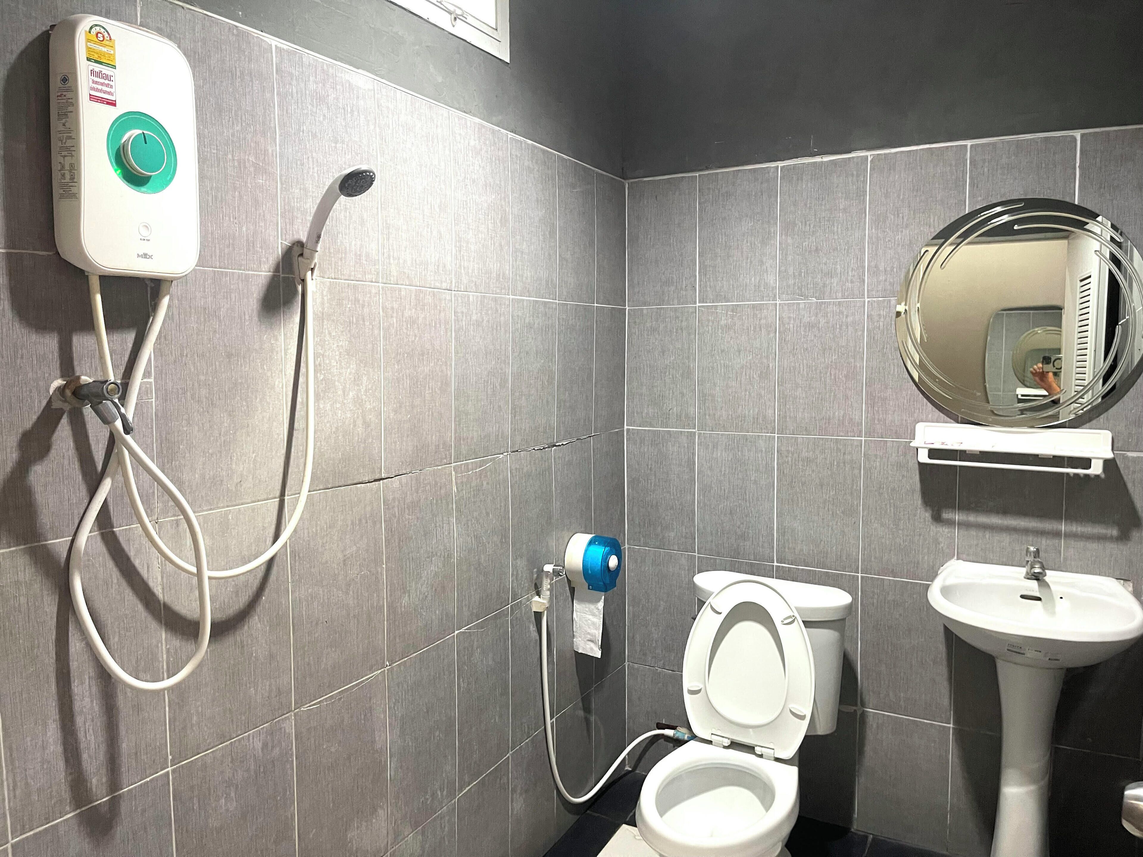 A bathroom with a toilet, a sink, and a shower unit.
