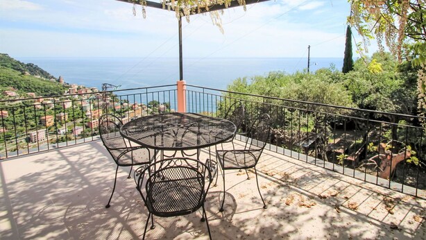 A terrace with a table and chairs, overlooking a coastal landscape. - Stunning private villa for 4 guests with A/C, TV, terrace and pets allowed (Zoagli)