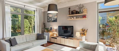 A modern living room with a sofa, TV, and decorative items.