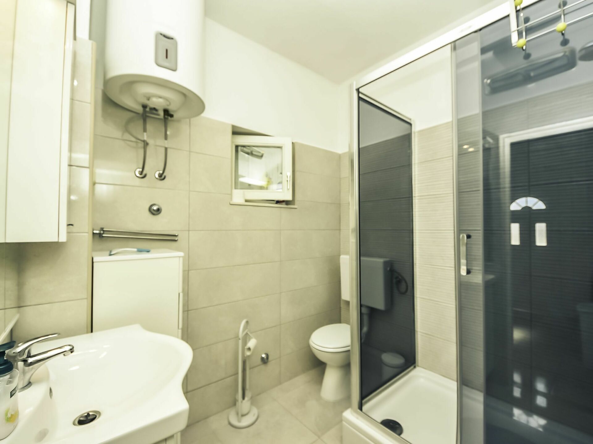 Ein modernes Badezimmer mit Waschbecken, Toilette und einer Duschkabine.