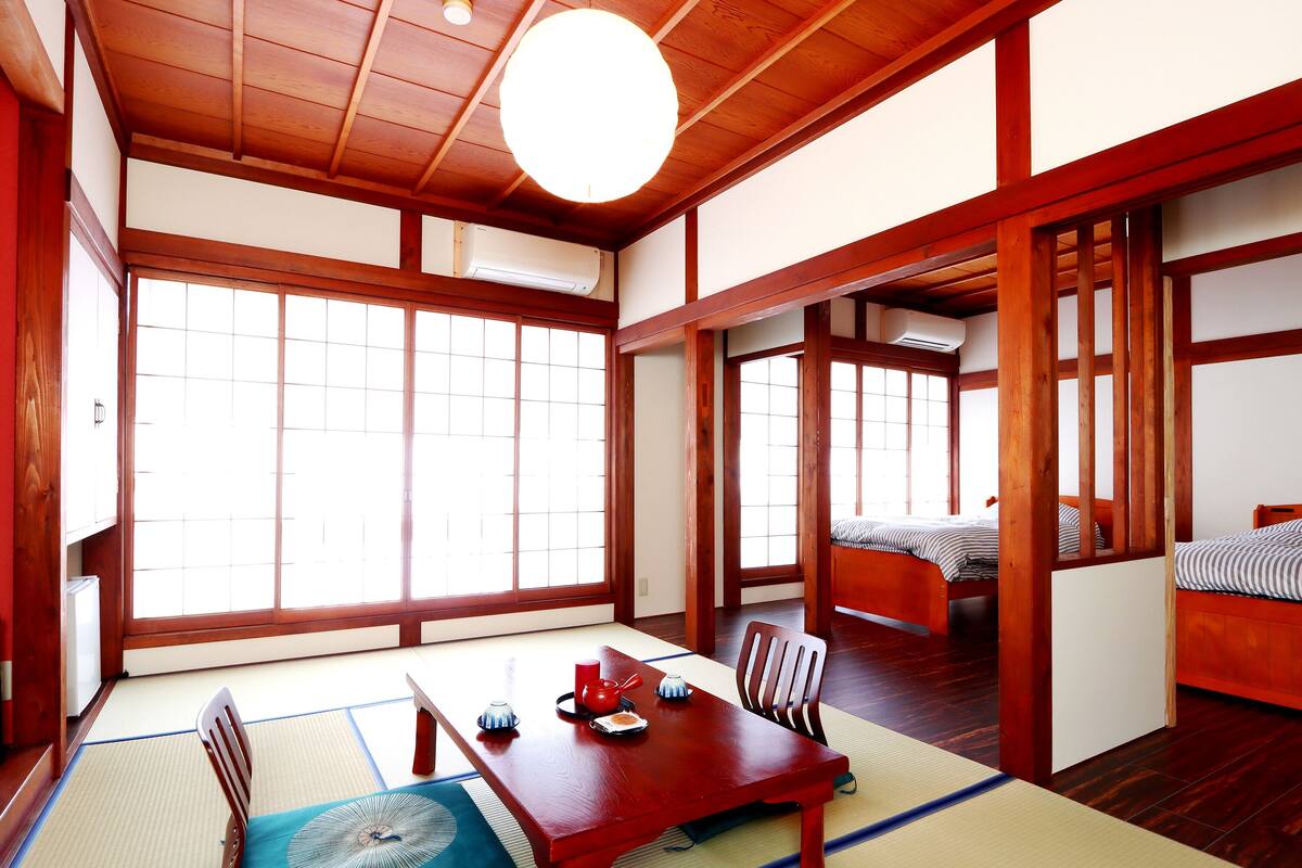 A traditional Japanese room with tatami flooring, a low wooden table, and sliding doors.