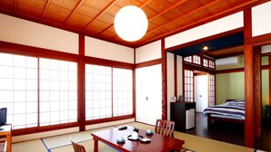 A traditional Japanese room with tatami flooring, a wooden table, and a futon bed. - Gokayama Ryokan Yoshinoya (Nanto)