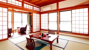 A traditional Japanese room with tatami flooring, a low wooden table, and sliding doors. - Gokayama Ryokan Yoshinoya (Nanto)