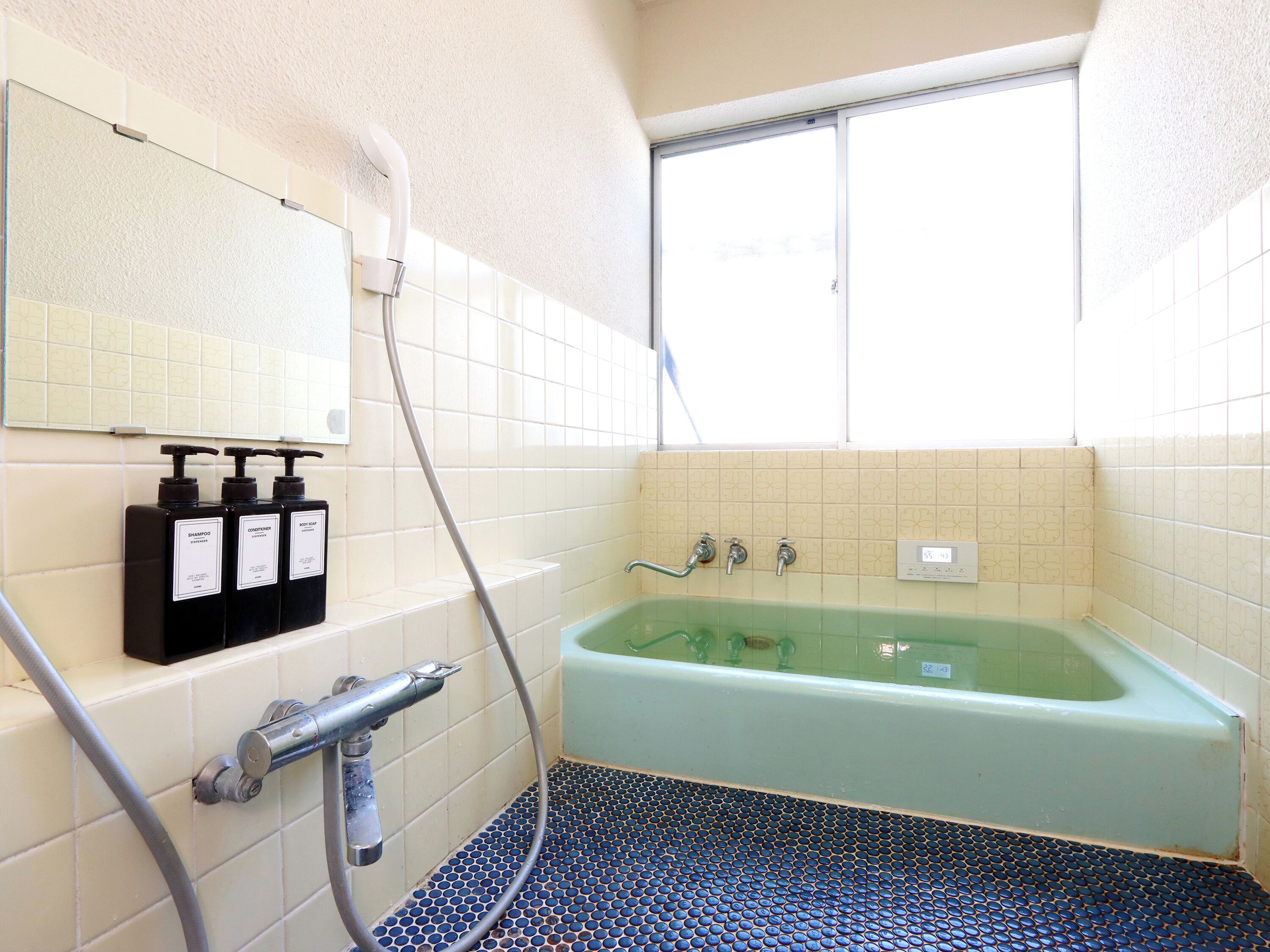 Un bagno con una vasca, una doccia e uno specchio.