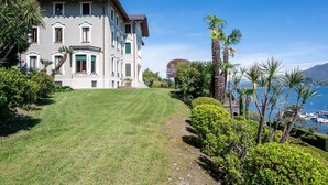 Un edifici gran de diverses plantes amb un jardí ben cuidat i vistes al mar.