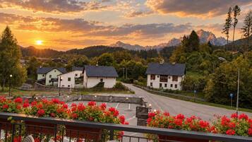 A residential area with houses, a road, and a sunset view.