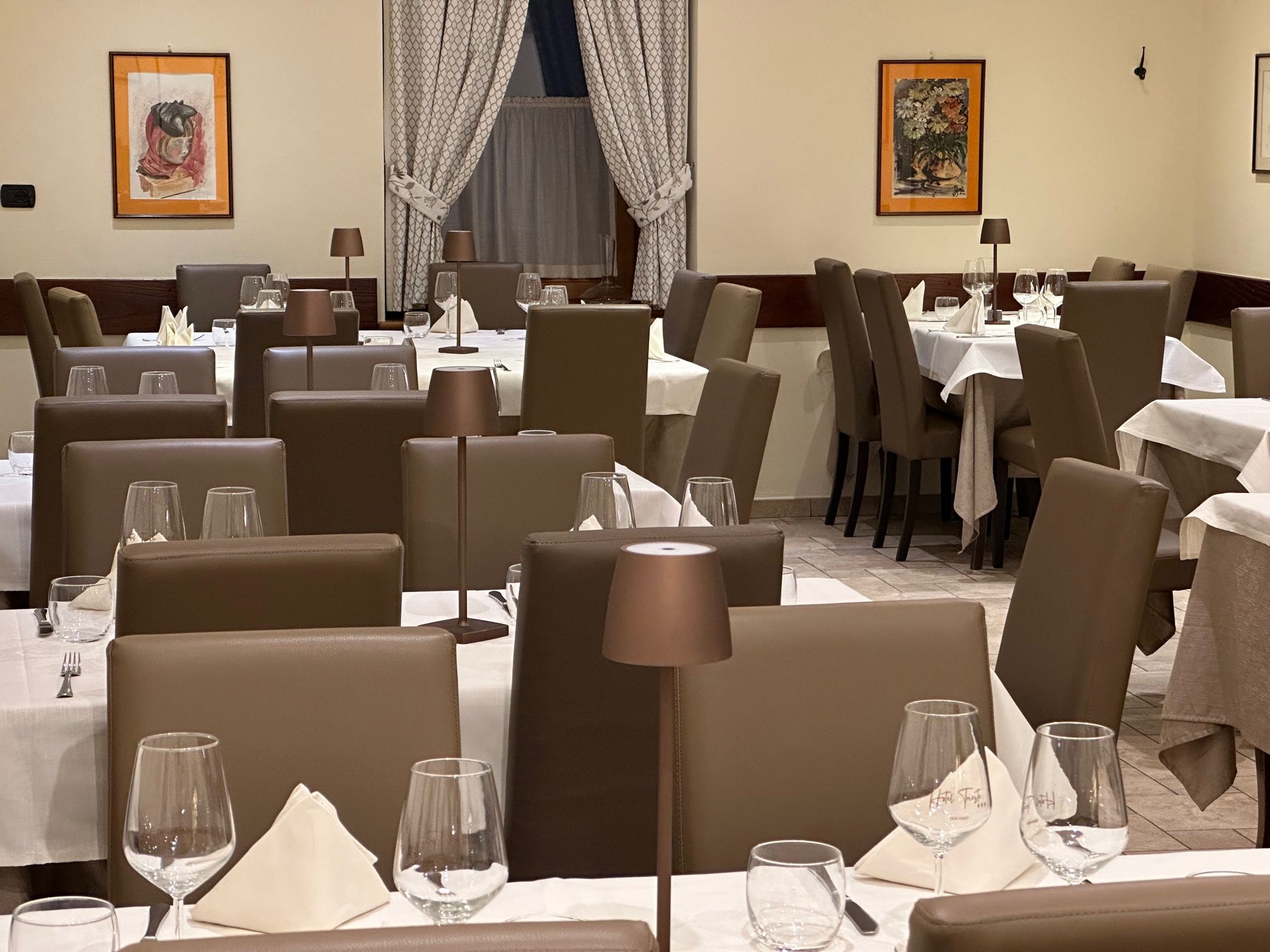 A restaurant interior with multiple tables, chairs, and dining tables.
