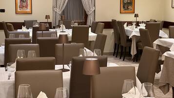 A restaurant interior with multiple tables, chairs, and dining tables.