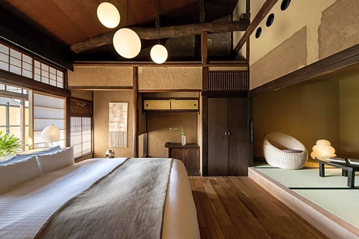 Une chambre de style japonais traditionnel, avec un sol recouvert de tatamis, un lit bas en bois et une porte coulissante de type shoji.