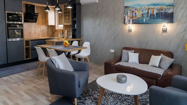 Un intérieur moderne comprenant un coin repas, un canapé et une cuisine.