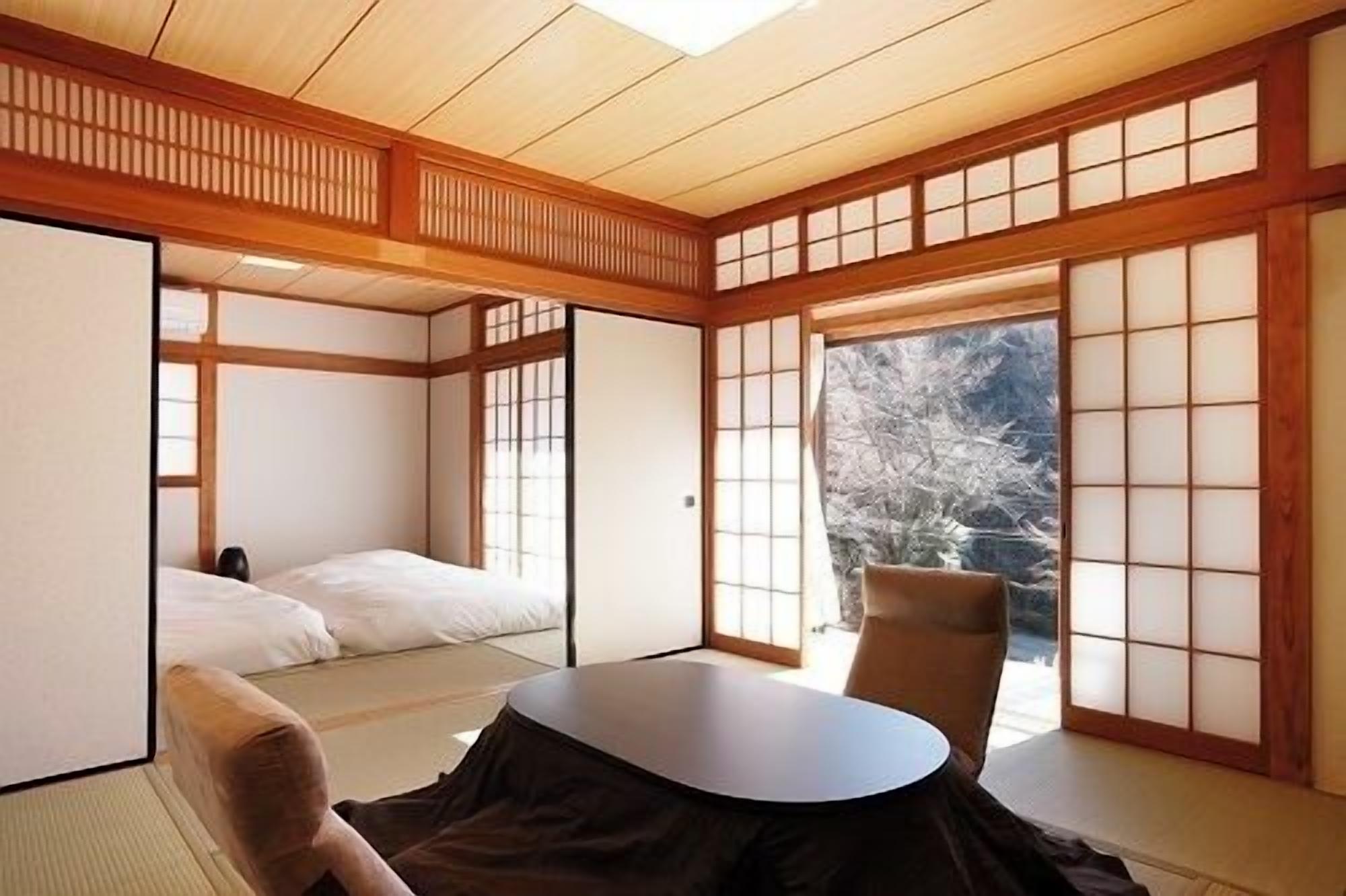 A traditional Japanese room with tatami flooring, a low table, and sliding doors.