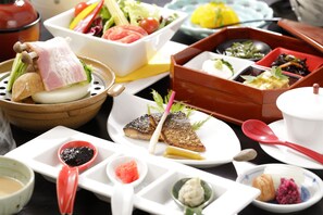 A variety of dishes and utensils on a table, including a bowl with a piece of meat, a plate with fish, and several small dishes with different sauces. - Hakone Fura (Hakone)