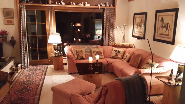 A cozy living room with a sectional sofa, a coffee table, a lamp, and a rug.