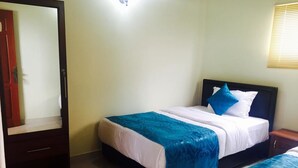 Un dormitorio con cama, mesita de noche, espejo y puerta.