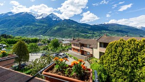A residential area with houses, a road, and mountains in the background. - Holiday Apartment "Casa Margherita" in Idyllic Location (Aosta)