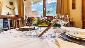 A dining table set with plates, glasses, and a wine bottle. - Holiday Apartment "Casa Margherita" in Idyllic Location (Aosta)