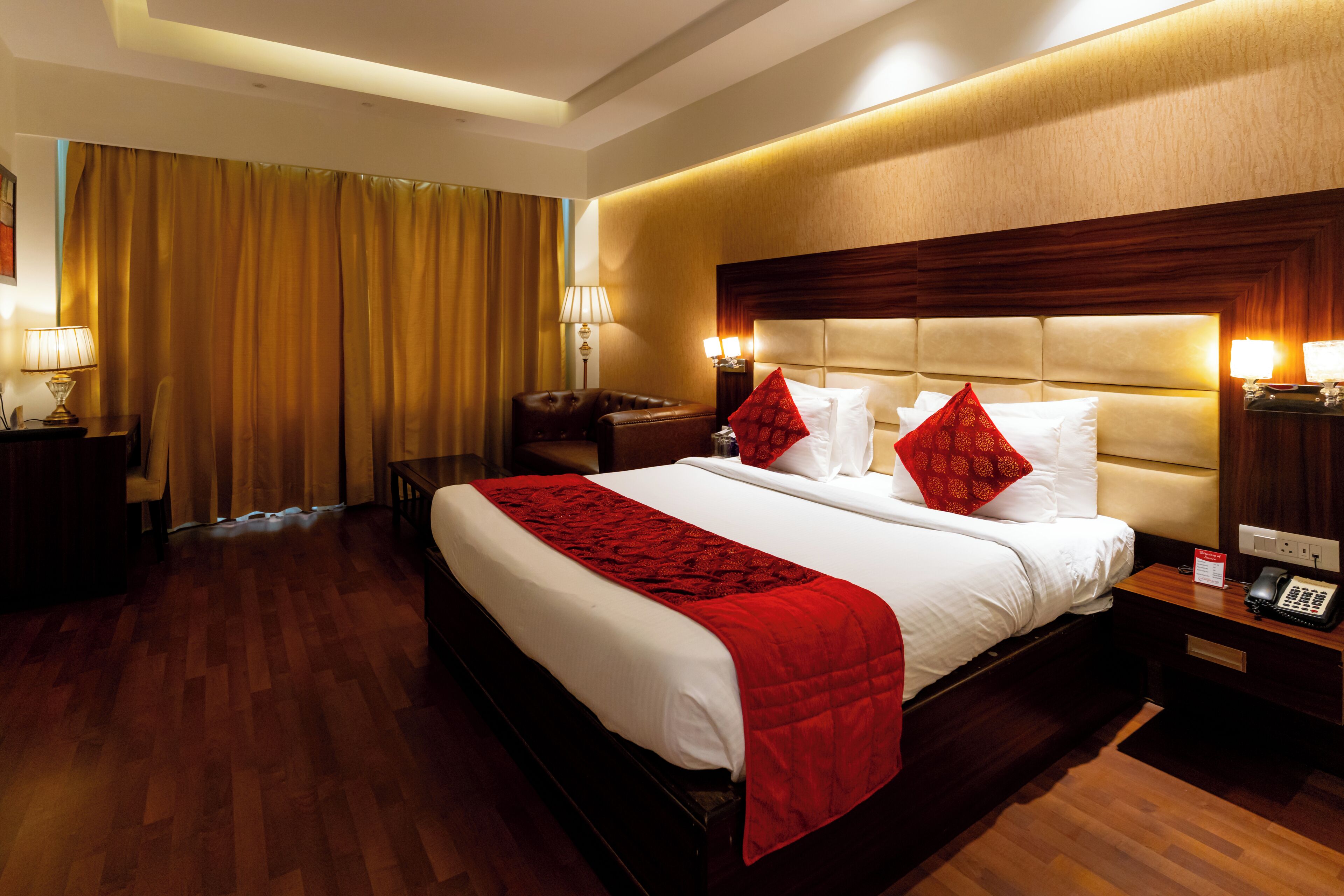A hotel room with a large bed, bedside tables, a desk, and a chair.