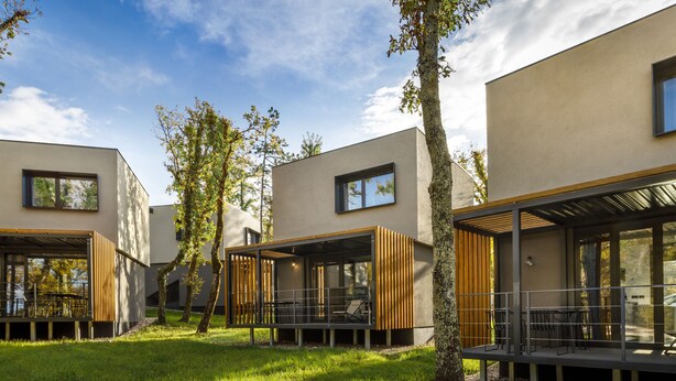Een modern gebouw met grote ramen en terrassen.