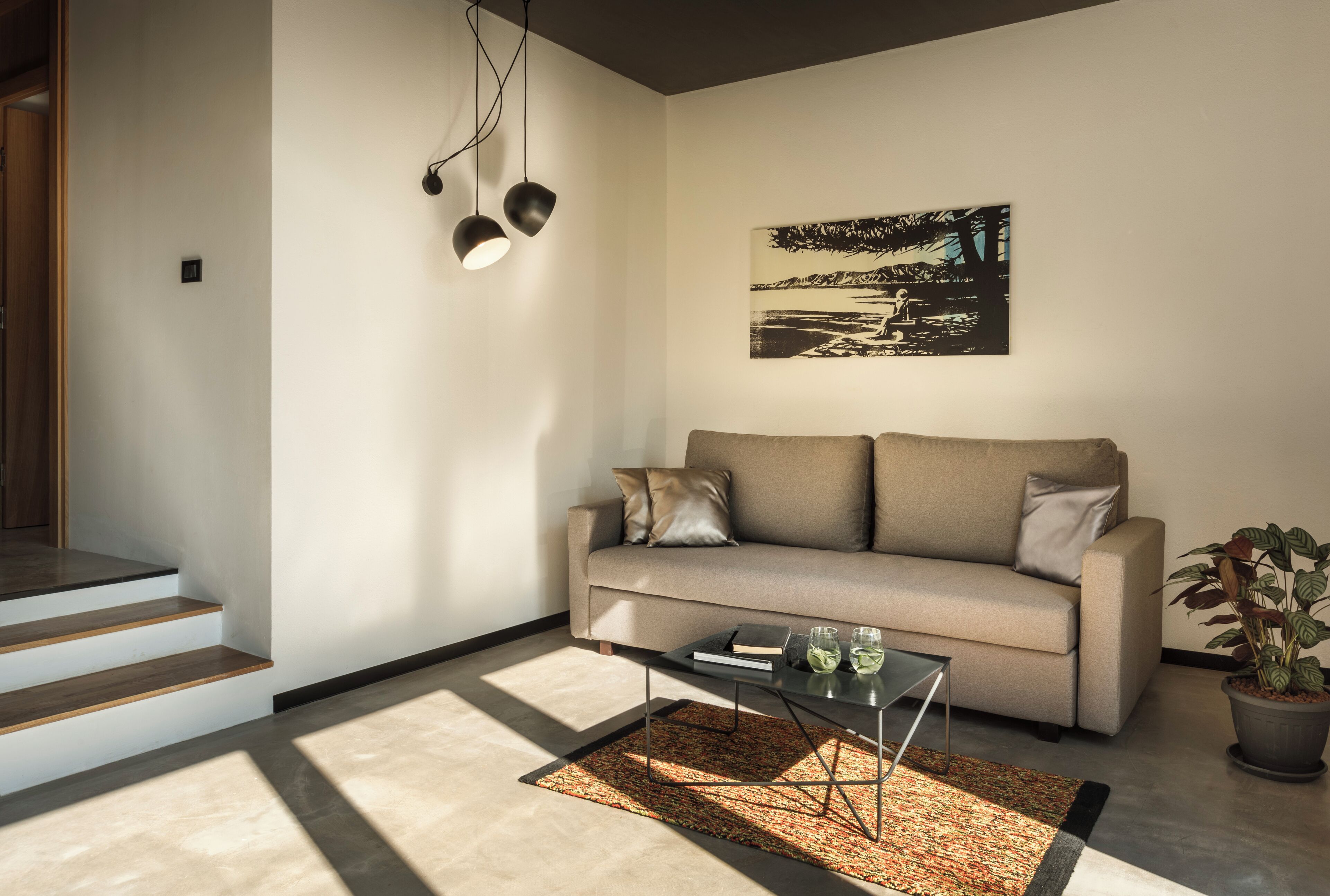 A modern living room with a sofa, coffee table, and a painting on the wall.