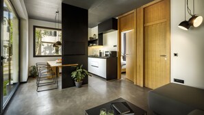 Een moderne keuken met een eethoek, een bank en een salontafel met boeken en glazen.