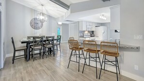 A modern kitchen with white cabinets, a built-in oven, and a white refrigerator. - Canal fun! Boat, Pool, Hot tub, Bikes & Kayaks (Cape Coral)