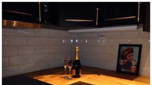 A kitchen with a wooden countertop, a bottle of champagne, and two glasses. - Alpstigen 8b (Jarvso)