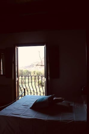 A dimly lit room with a bed and a window overlooking a balcony. - Borgo della Marinella (Amantea)