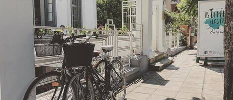 A bicycle parked in front of a hostel with a sign indicating it is a hostel.