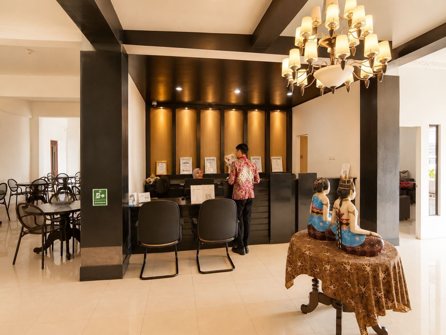 A reception area with a counter, chairs, and a chandelier.