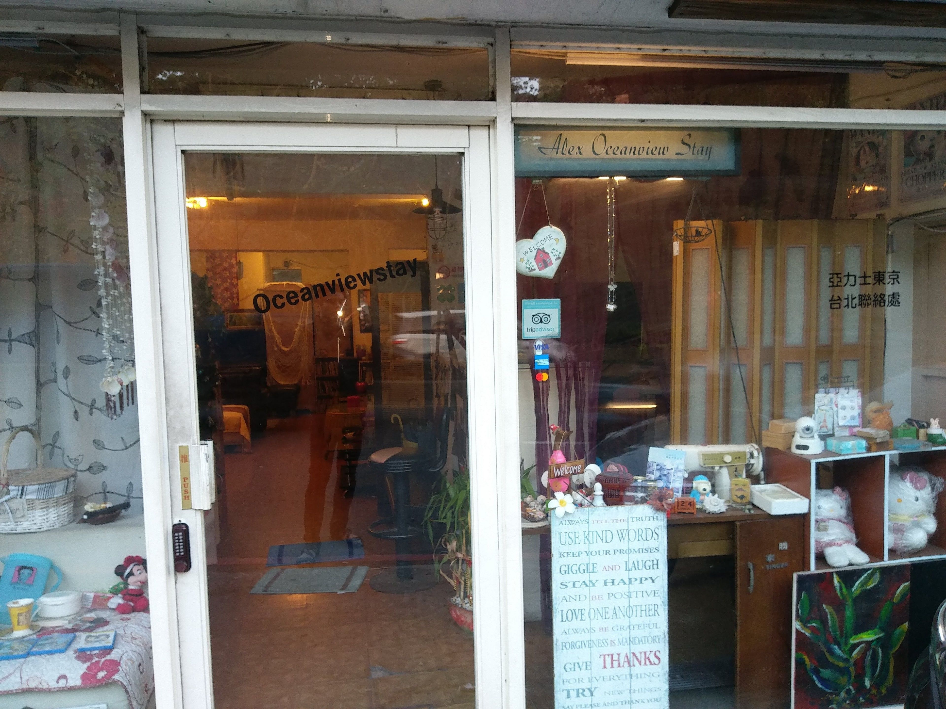 A cozy interior with a visible entrance labeled "Oceanview Stay," a welcoming sign, and a variety of items on display including a teddy bear and a framed painting.