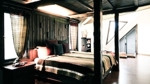 A bedroom with a bed, curtains, a nightstand, and a dresser.
