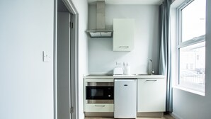 Una cocina compacta con horno integrado, lavavajillas y ventana que proporciona luz natural.