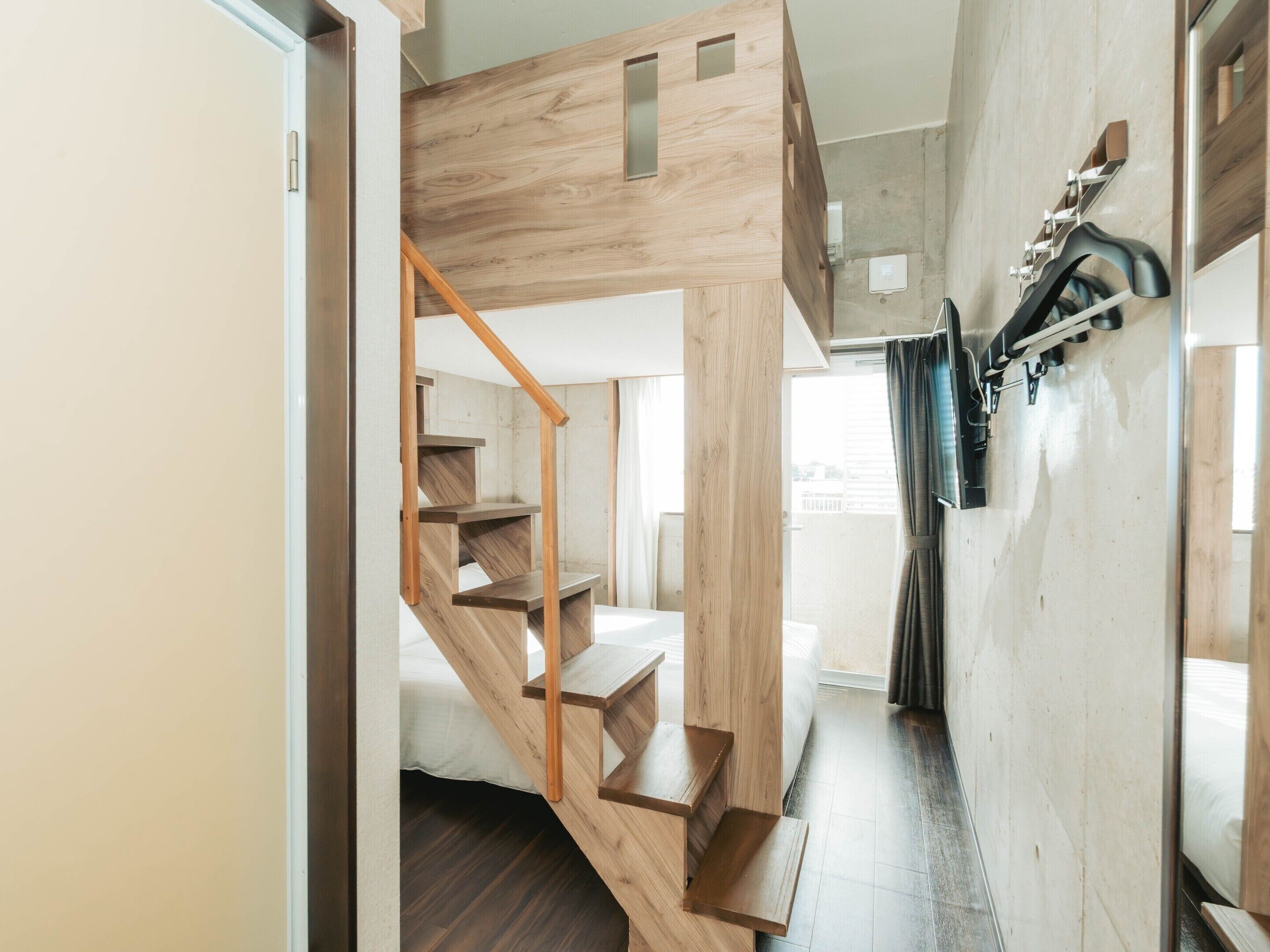 Un interno moderno con una scala in legno, un letto e un bagno con doccia.