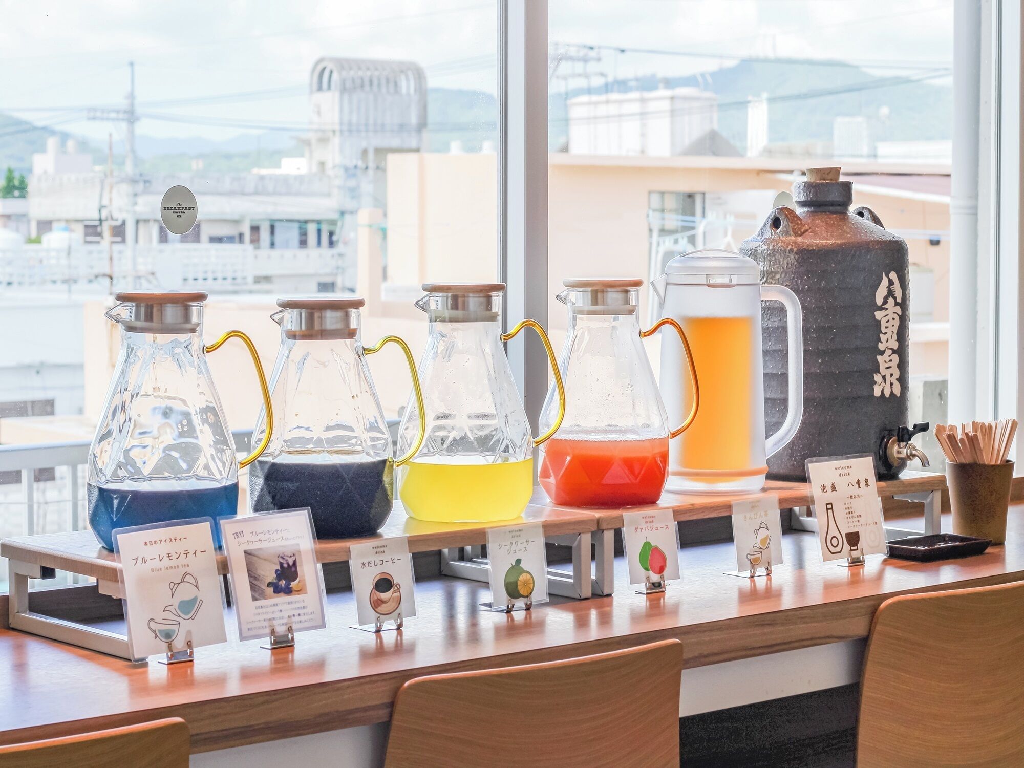 A beverage station with various drink dispensers and labels in a cafe setting.