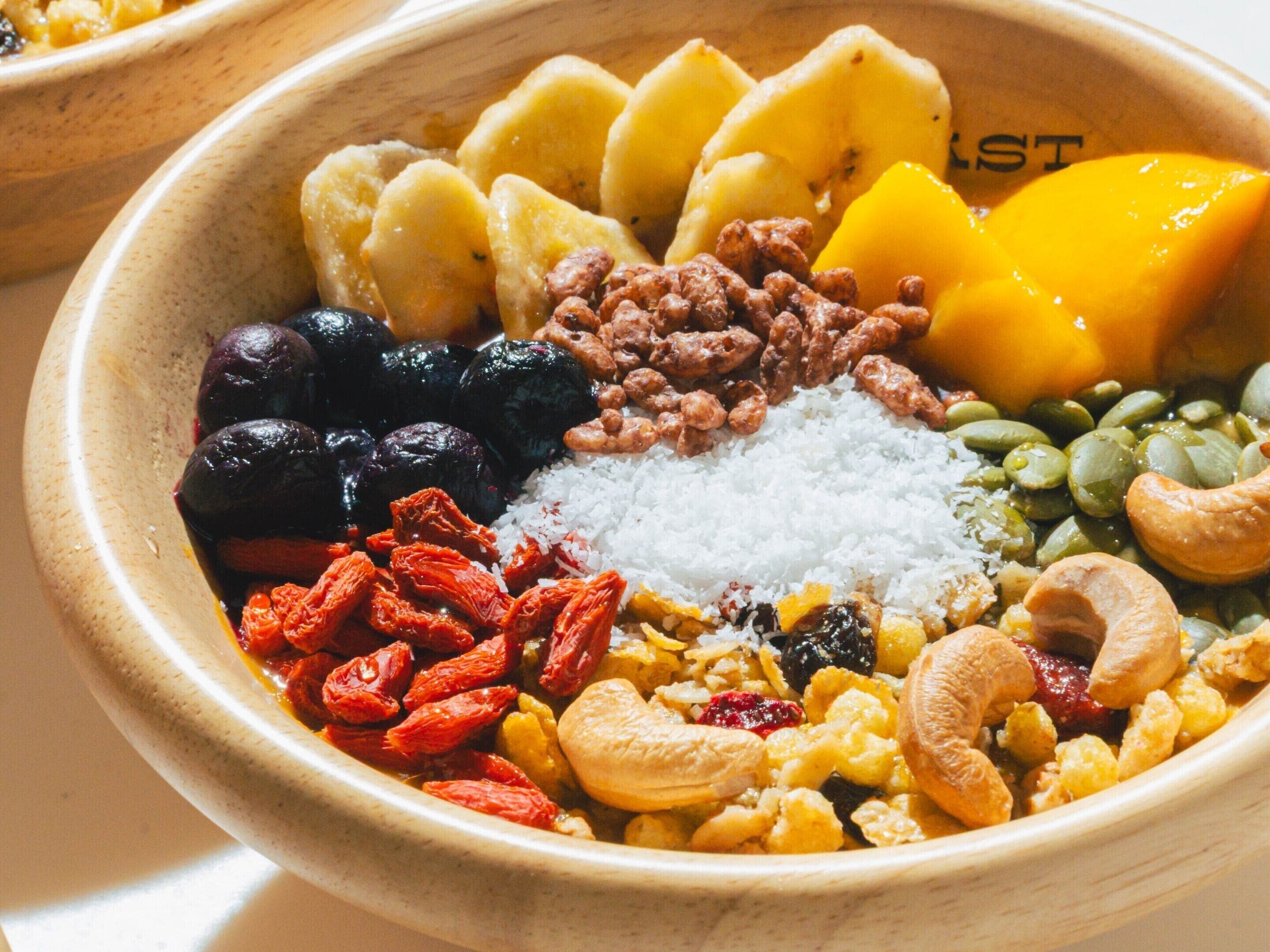 Un tazón con una mezcla de nueces, frutas secas y semillas.
