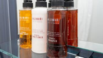 Four Hajimari hair care products on a glass shelf.