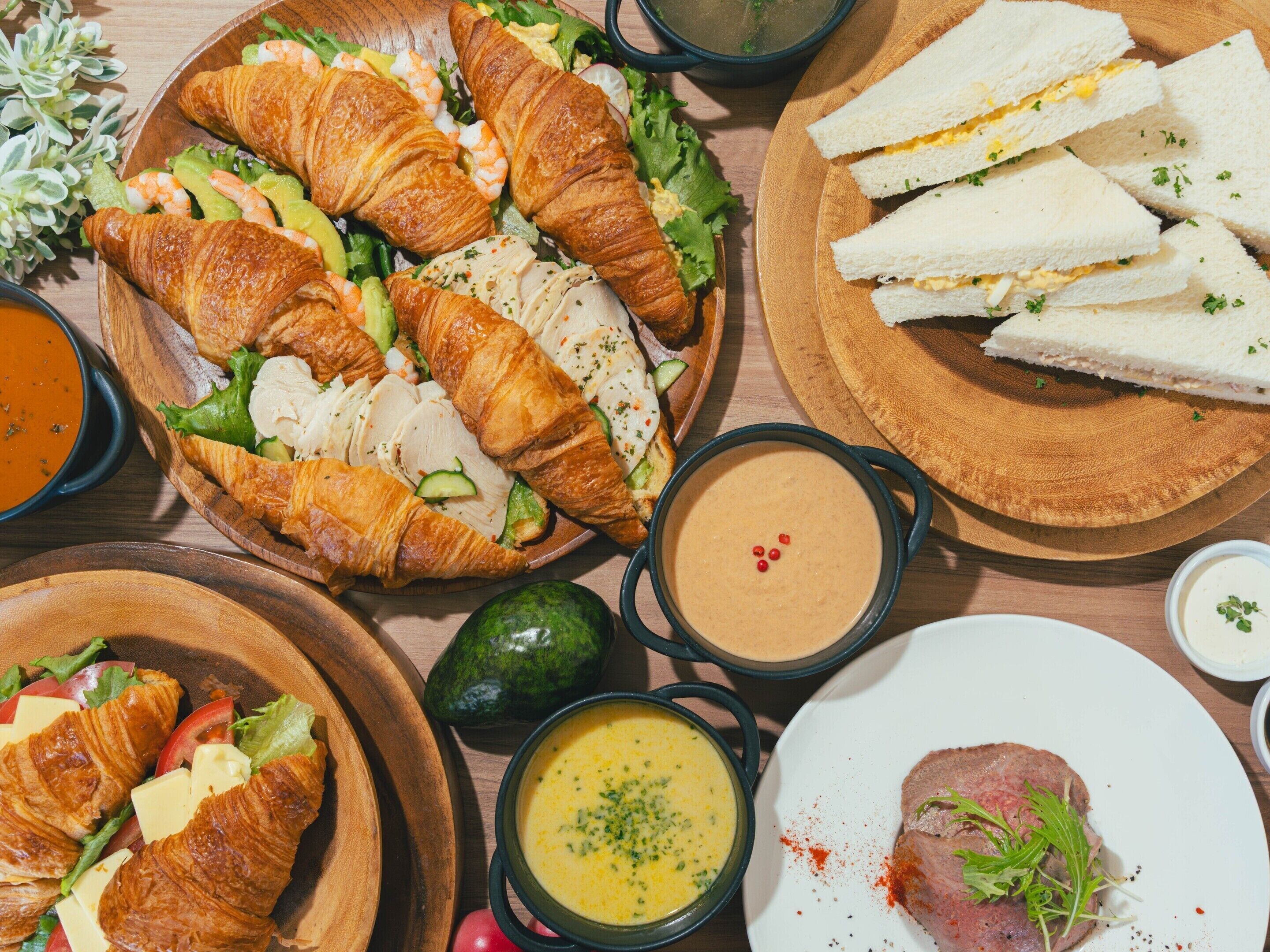 Diversos alimentos como cruasanes, sándwiches y tazones de sopa.