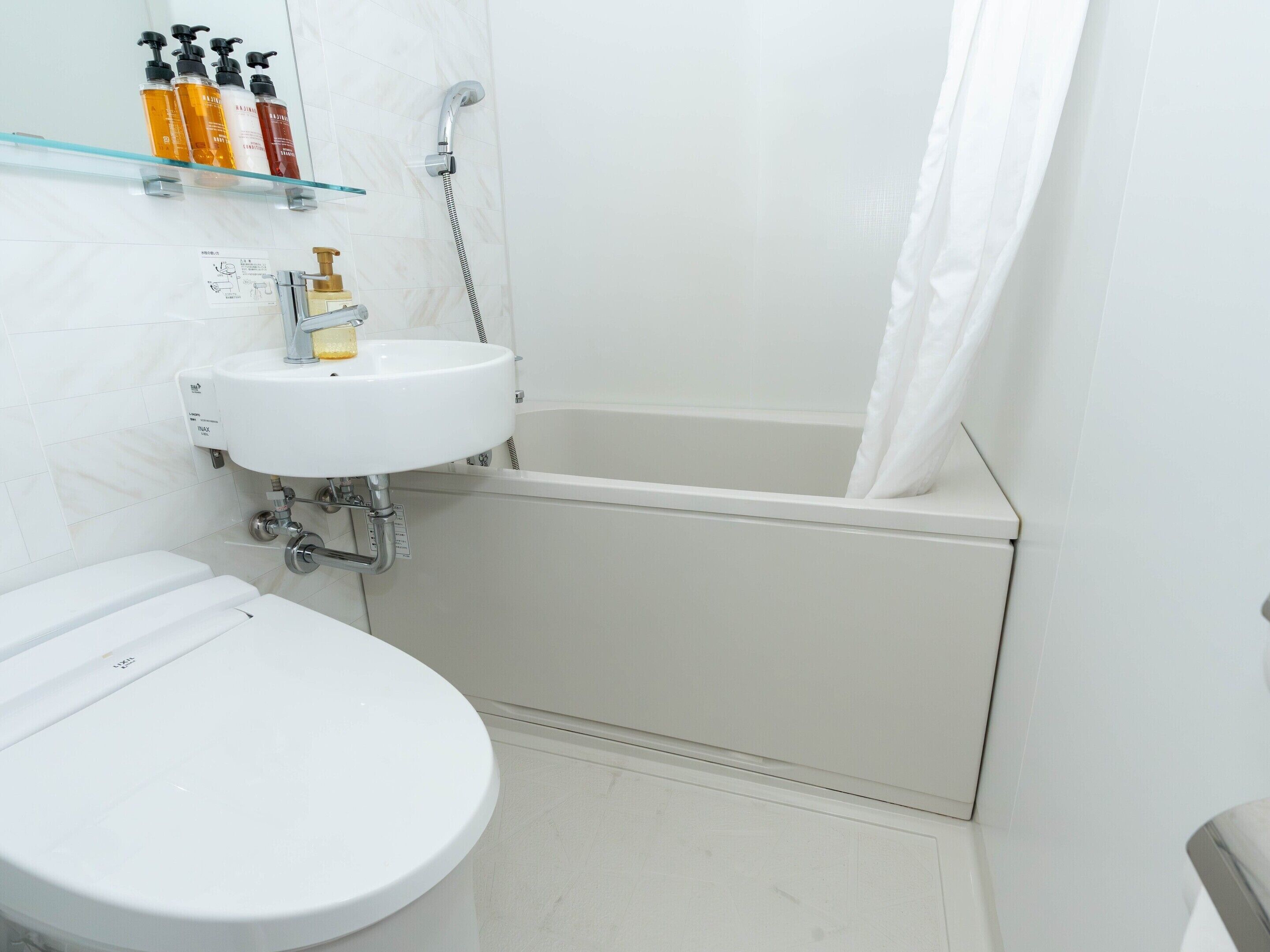 A bathroom with a toilet, a sink, and a bathtub.