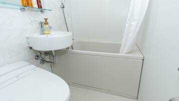A bathroom with a toilet, a sink, and a bathtub.