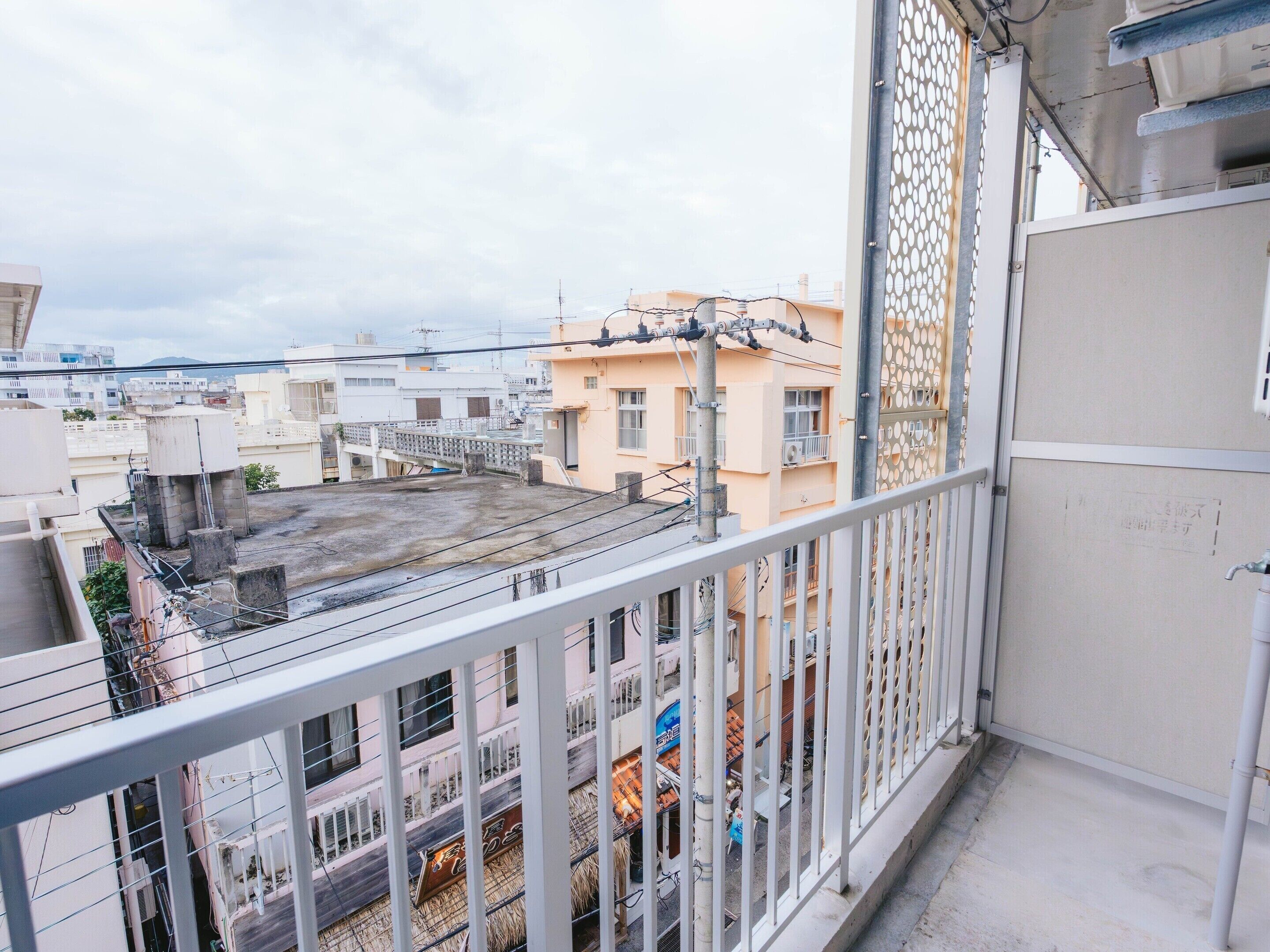 Un balcón con vistas a edificios cercanos y una azotea.
