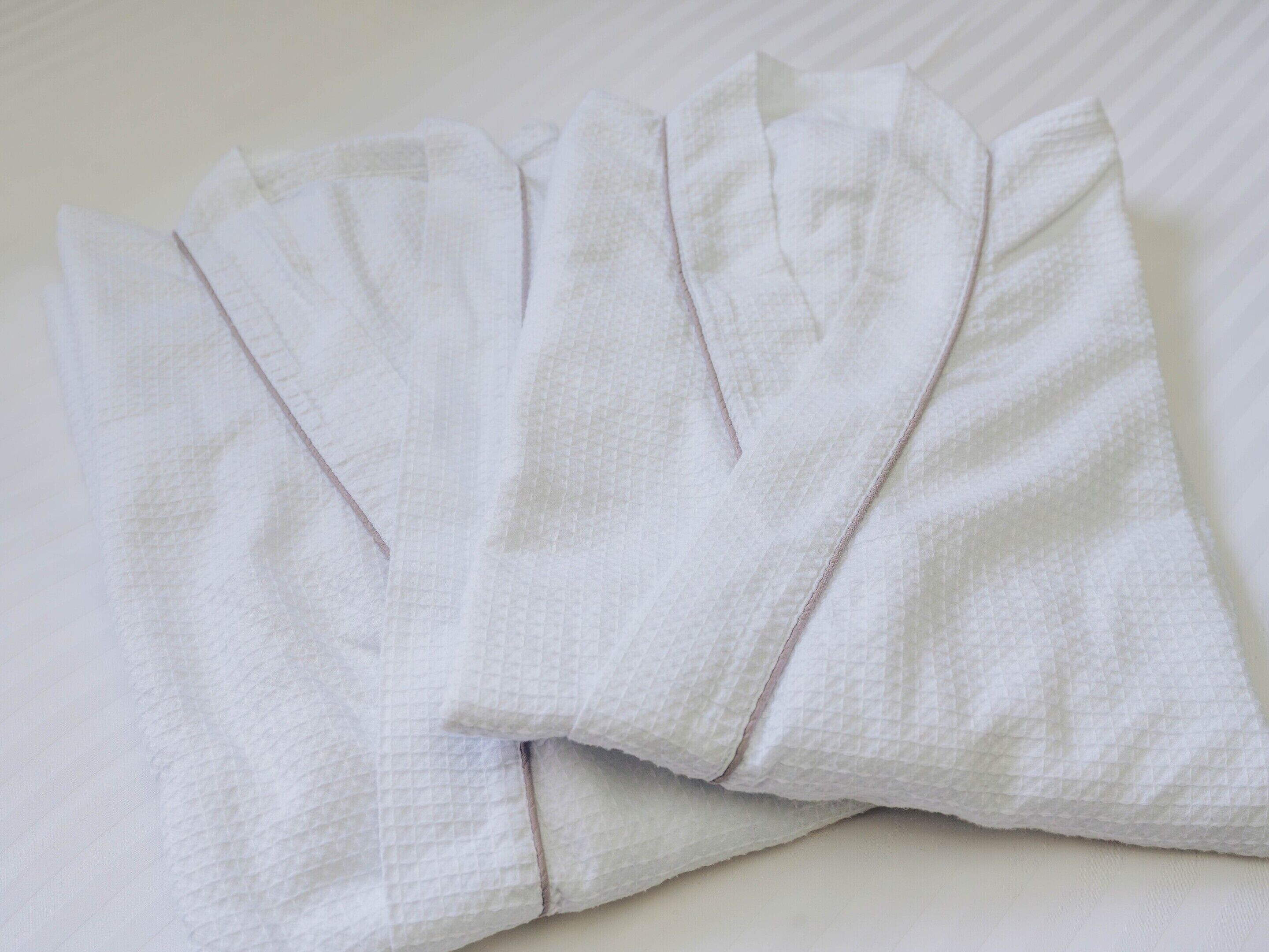 A set of white towels laid out on a bed.