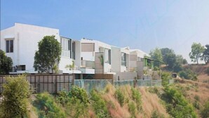 A modern residential building with a flat roof, large windows, and a mix of white and grey exterior walls. - SkyWater Villas And Lifestyle (Igatpuri)